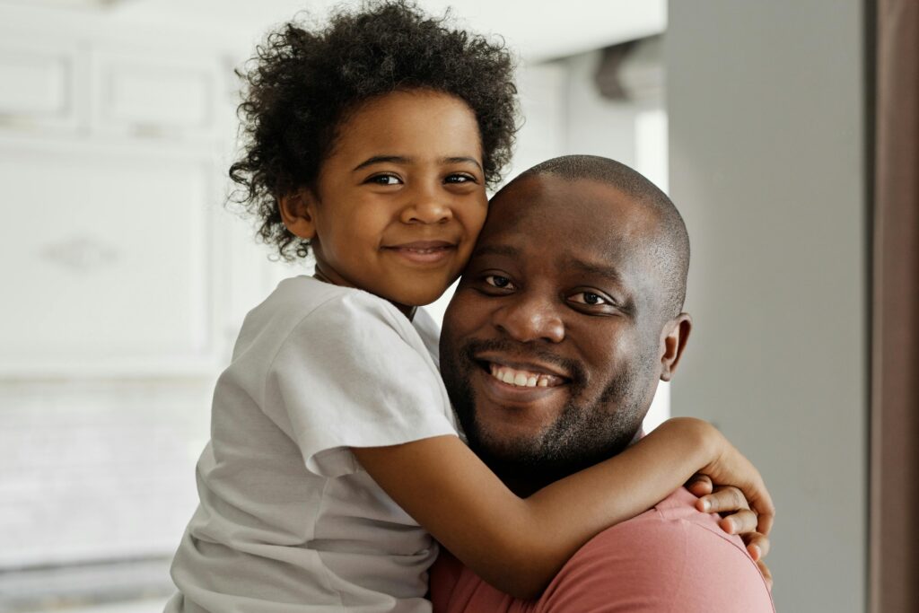 Heartwarming moment of father and son sharing a joyful embrace indoors, showcasing family love.
